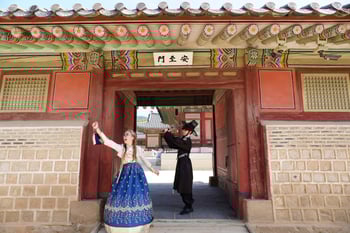Students dressed in traditional Korean hanbok at a historic palace gate in Seoul. Students dressed in traditional Korean hanbok at a historic palace gate in Seoul.