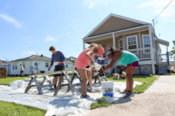 Group of students painting a fence outside a home in New Orleans as part of a rebuilding project. Group of students painting a fence outside a home in New Orleans as part of a rebuilding project.